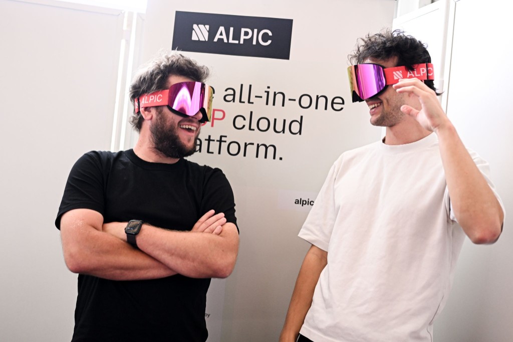 Two Alpic team members laughing while wearing the pink Alpic ski goggles